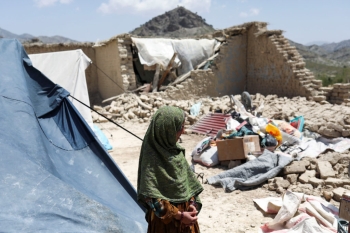 An Afghan girl stands near her house that was damaged by an earthquake in Kalizei village in the Gayan district of Paktika province, Afghanistan, June 26, 2022. REUTERS/Ali Khara