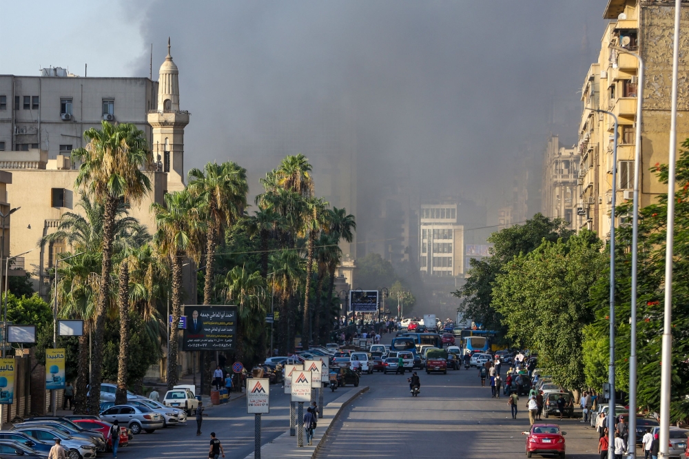 إجراء عمليات التبريد لمنع تجدد حريق سنترال رمسيس - أ ف ب