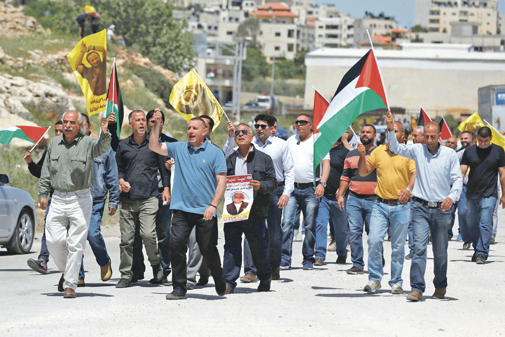 فلسطينيون خلال مظاهرة أمام سجن عوفر تضامنا مع السجناء (أ.ف.ب)