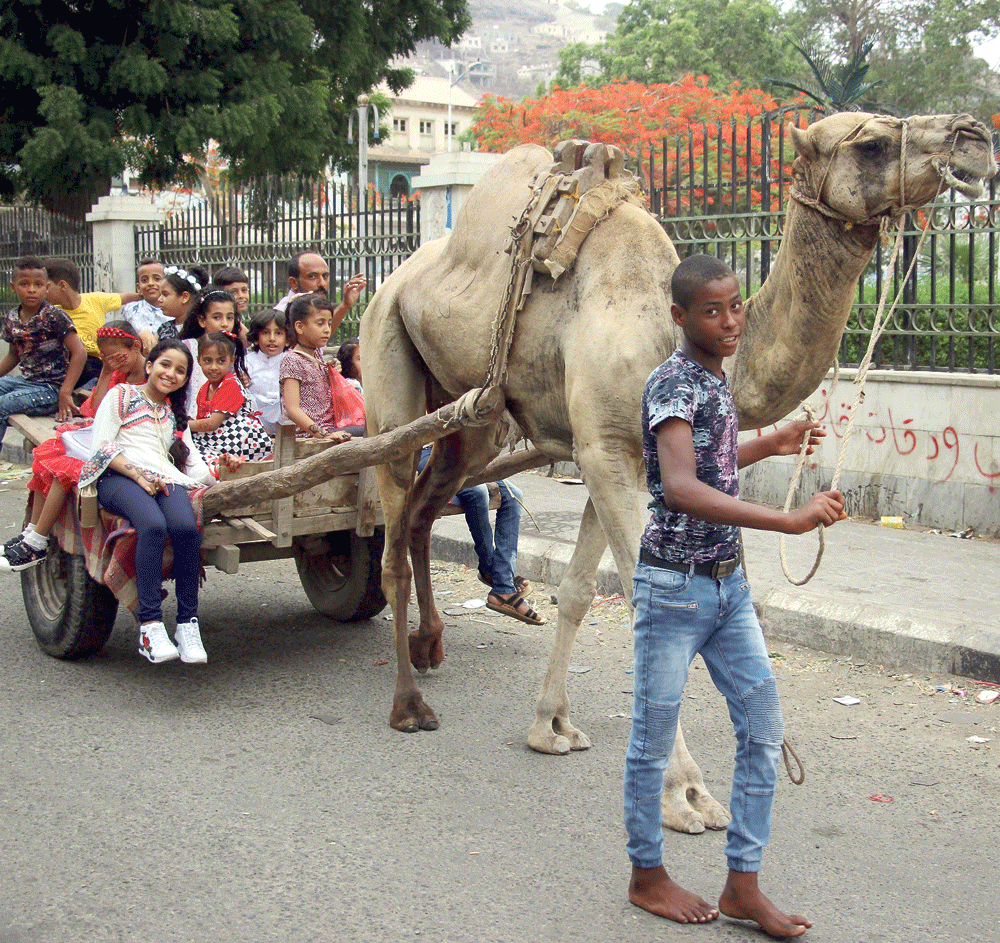 أطفال يمنيون يتنزهون في احتفالات عيد الأضحى المبارك بمدينة عدن (إ.ب.أ)