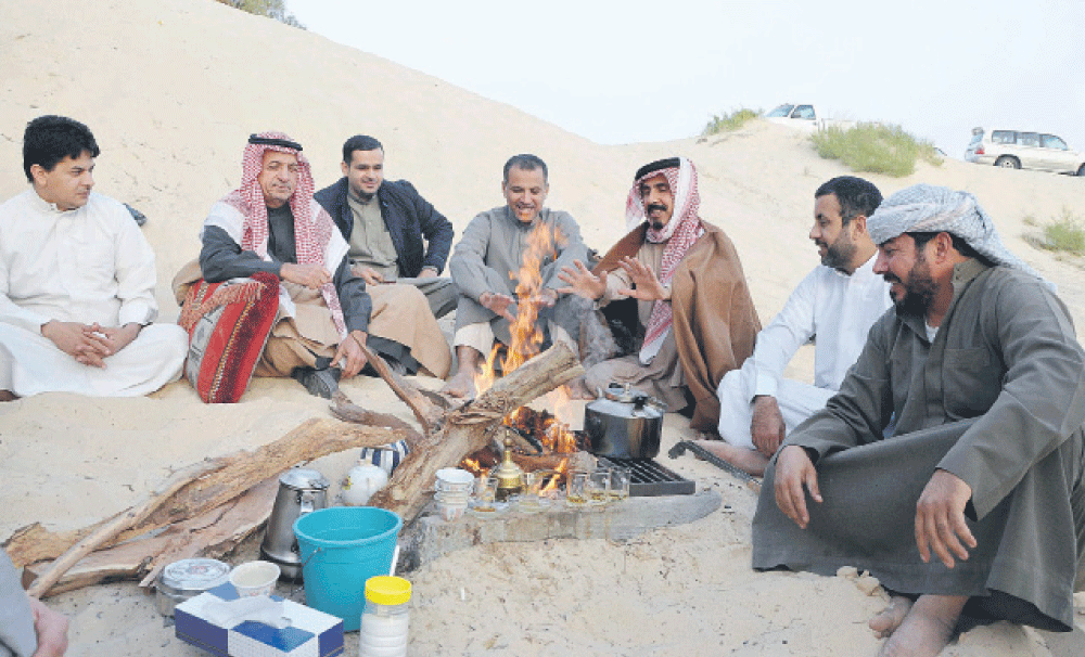 رواد بـر يمضون وقتهم حول شبة النار (تصوير: حمزة بوفهيد)